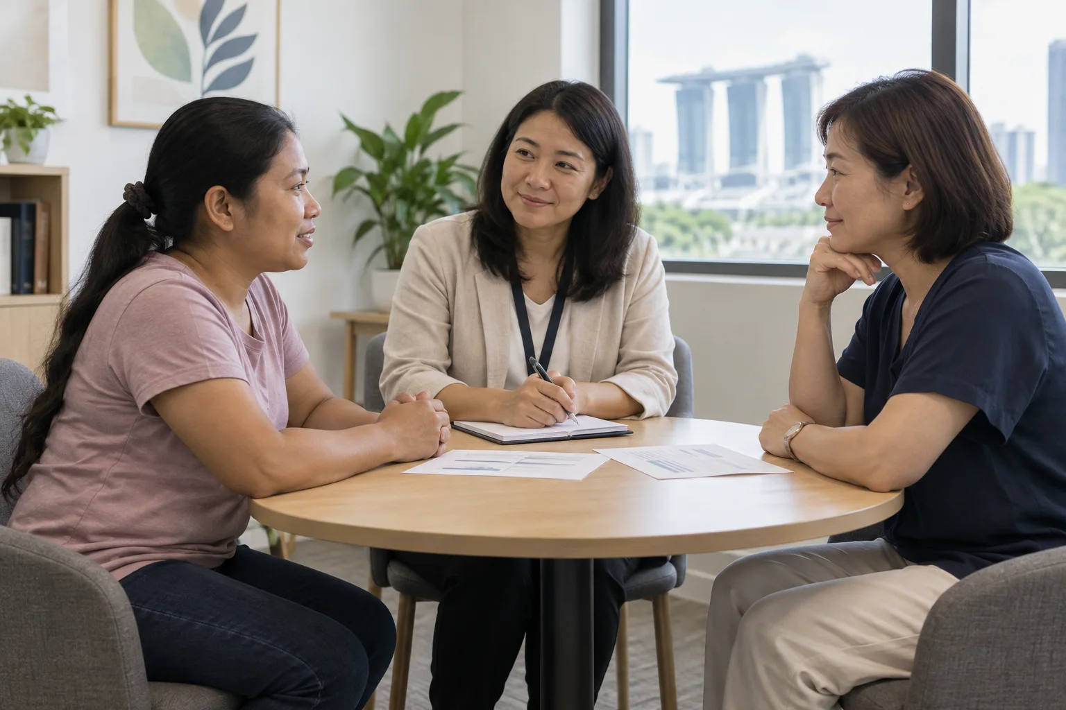 A domestic helper and employer having a calm mediation conversation with a neutral facilitator in Singapore